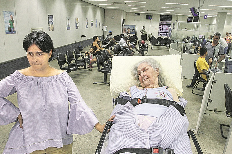 Dona Vitalina dentro da agência bancária: idosa precisou da ajuda de socorristas para entrar no banco e conseguir receber. (Foto: Kadidja Fernandes/AT)