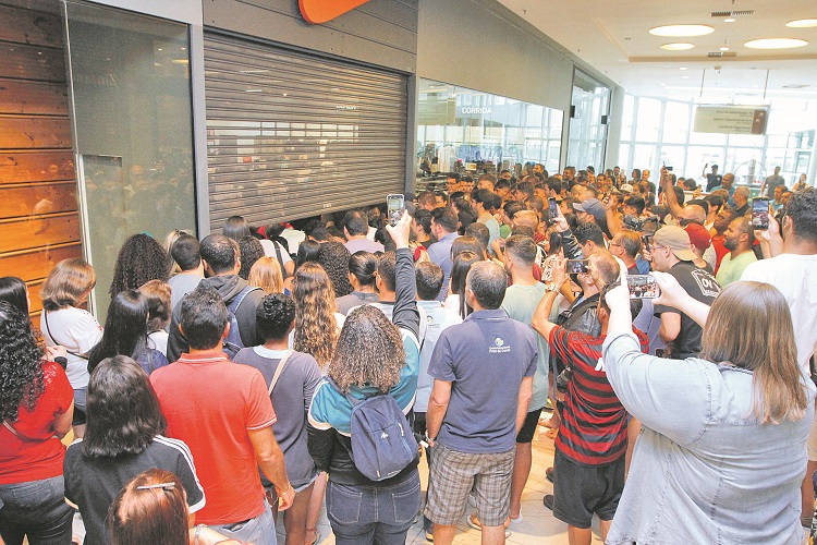 Multidão aguarda a abertura em loja de shopping no período da