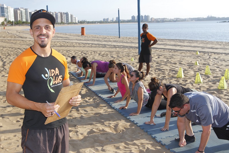 O professor Pedro Muniz orienta alunos na praia de Camburi. “Exercício de manhã deixa a pessoa mais disposta”, disse (Foto: Leone Iglesias/ AT)