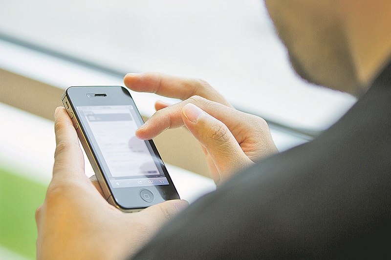 Jovem mexe em aplicativo de celular. Uso da ferramenta permite entregas mais rápidas dos entorpecentes (Foto: Divulgação)