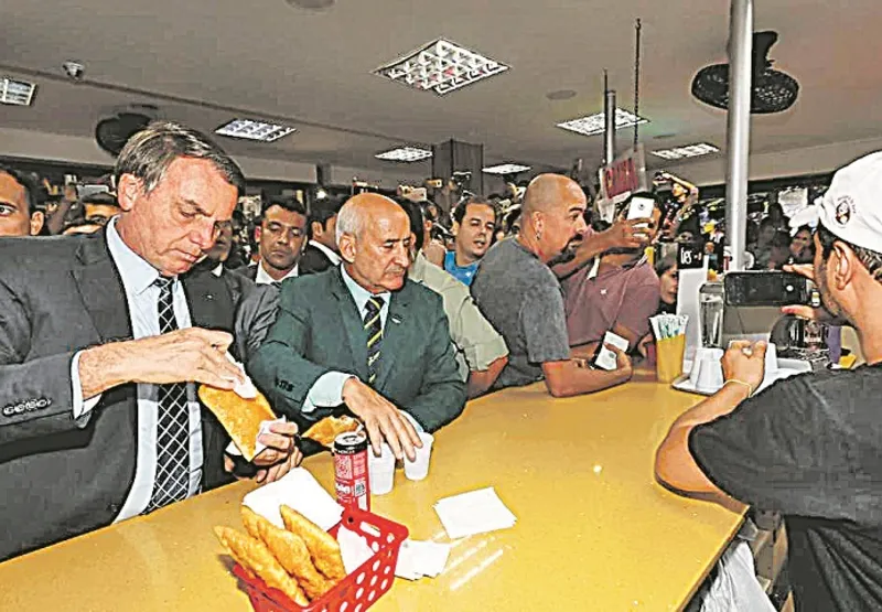 O presidente Jair Bolsonaro escapou para comer um pastel na Feira do Paraguai, em Brasília, nesta semana. Foi acompanhado de Luiz Eduardo Ramos.