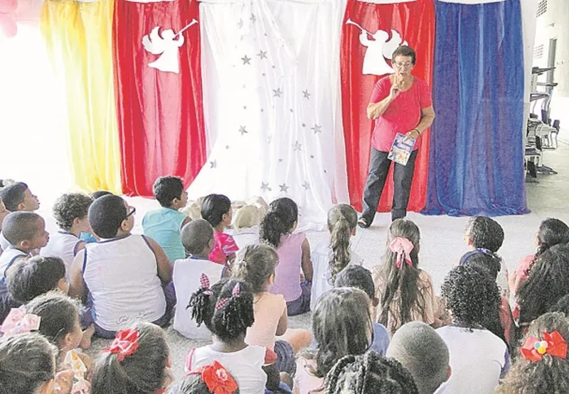 Professora Josmari Araújo dos Santos contando histórias para as crianças, uma cena que se repete há décadas