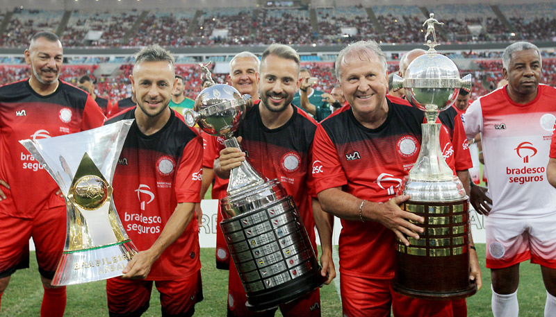 Rafinha, Everton Ribeiro e Zico exibem os títulos do Brasileirão, Libertadores de 2019 e Libertadores de 1981 (Foto: Luciano Belford / Agência O Dia / Agência Estado)