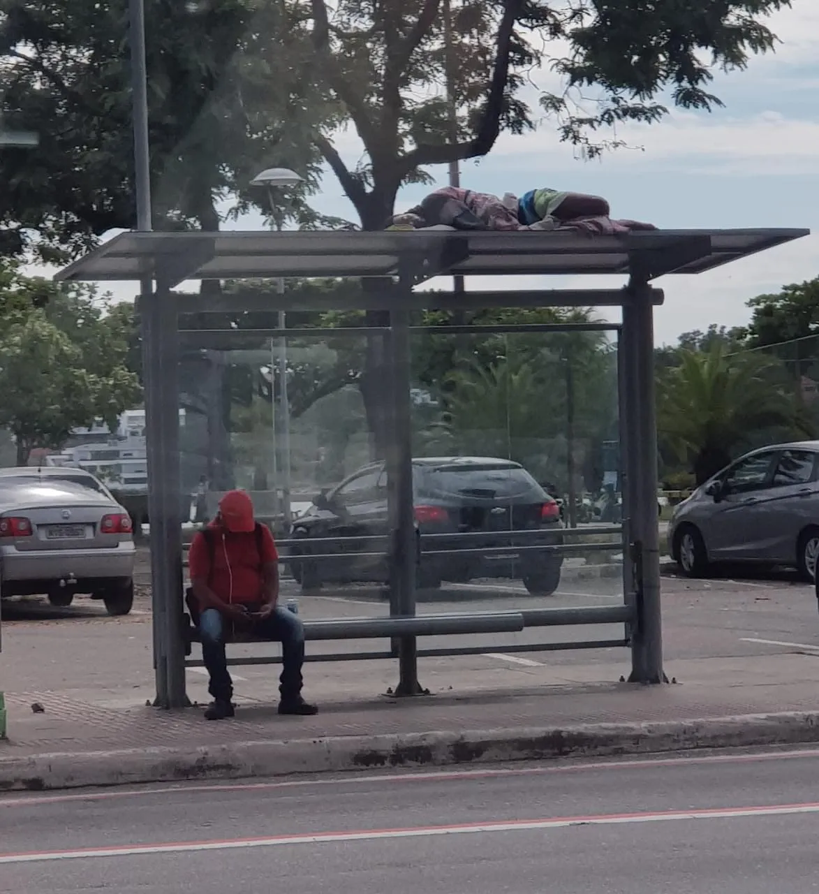 Morador de rua dorme em cima de ponto de ônibus em Vitória