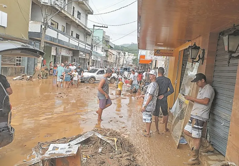 Após a chuva, moradores observam  destruição e rua tomada pela lama