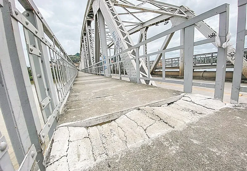 Placa de concreto está quebrada e com rachaduras na passarela lateral da ponte Florentino Avidos