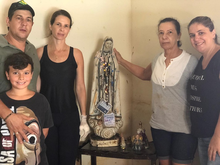 Dona Eliane aparece ao lado da família e da santa encontrada intacta após enchente (Foto: Filipe Chicarino/AT)