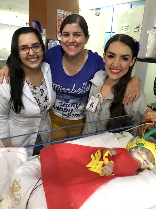 Patrícia (no meio) com a equipe da Utin posam para foto com a Mulher Maravilha Maria Clara (Foto: Divulgação/ Perinatal Vitória)