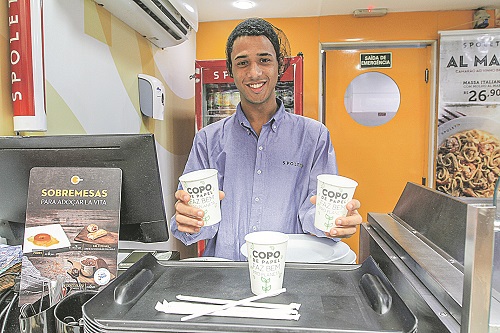 Assistente de gerente Ronaldo Araújo mostra copos e canudos de papel: “Os clientes têm elogiado a mudança” (Foto: Dayana Souza/AT)