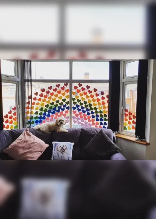 
          Imagem ilustrativa da imagem Crianças em quarentena desenham arco-íris e escrevem mensagens em janelas
          