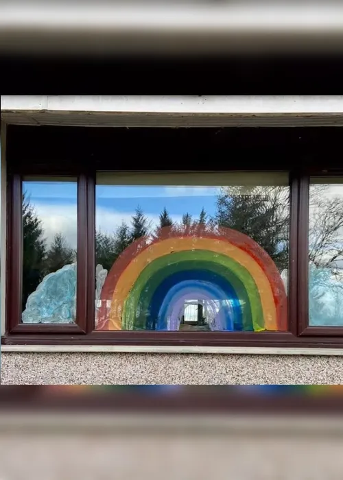 
          Imagem ilustrativa da imagem Crianças em quarentena desenham arco-íris e escrevem mensagens em janelas
          