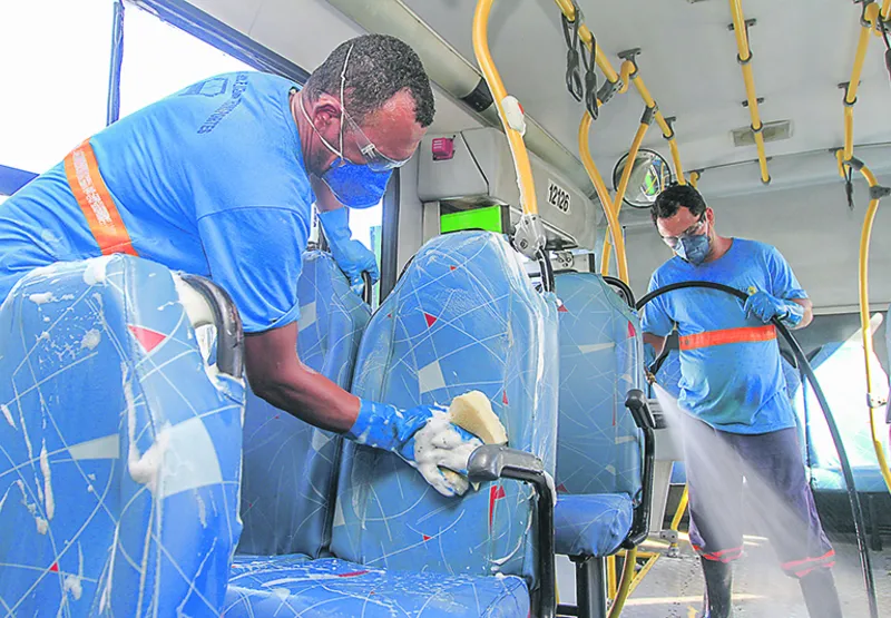 Funcionários fazem a higienização de ônibus, mas a limpeza não basta para impedir a disseminação do vírus