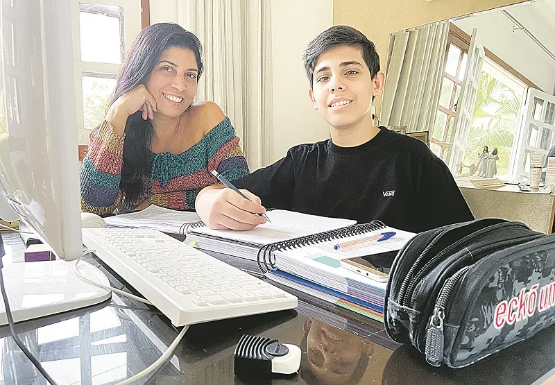 A operadora industrial Jussara Knaak  ajuda o filho Leonardo Rezende, de 14 anos, nos estudos em casa