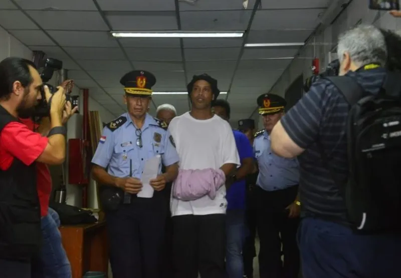Ronaldinho chegou algemado escoltado por policiais.