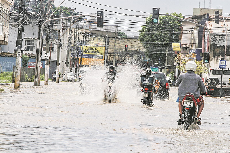 Motociclistas enfrentam vias alagadas em Cobilândia, Vila Velha. Outras regiões da cidade tiveram problemas (Foto: Fábio Nunes/ AT)