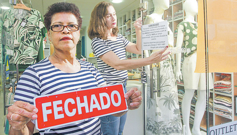 Cynthia e Dora colocaram placa e cartaz em frente à loja para avisar que o funcionamento seria interrompido (Foto: Kadidja Fernandes / AT)