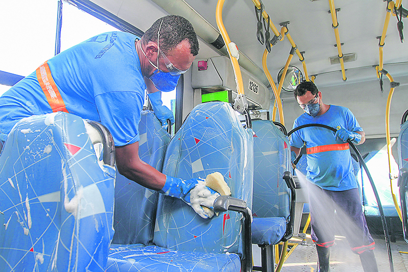 Funcionários fazem a higienização de ônibus, mas a limpeza não basta para impedir a disseminação do vírus (Foto: Dayana Souza/AT)