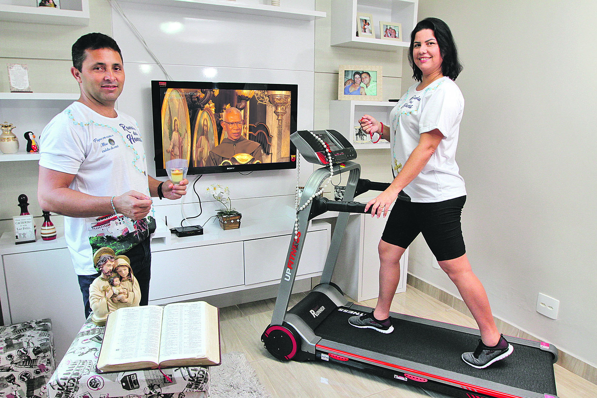 Alineanda na esteira na sala da sua casa sendo observada pelo marido Adenilson, que vai acompanhar a mulher durante a romaria (Foto: Beto Morais/AT)