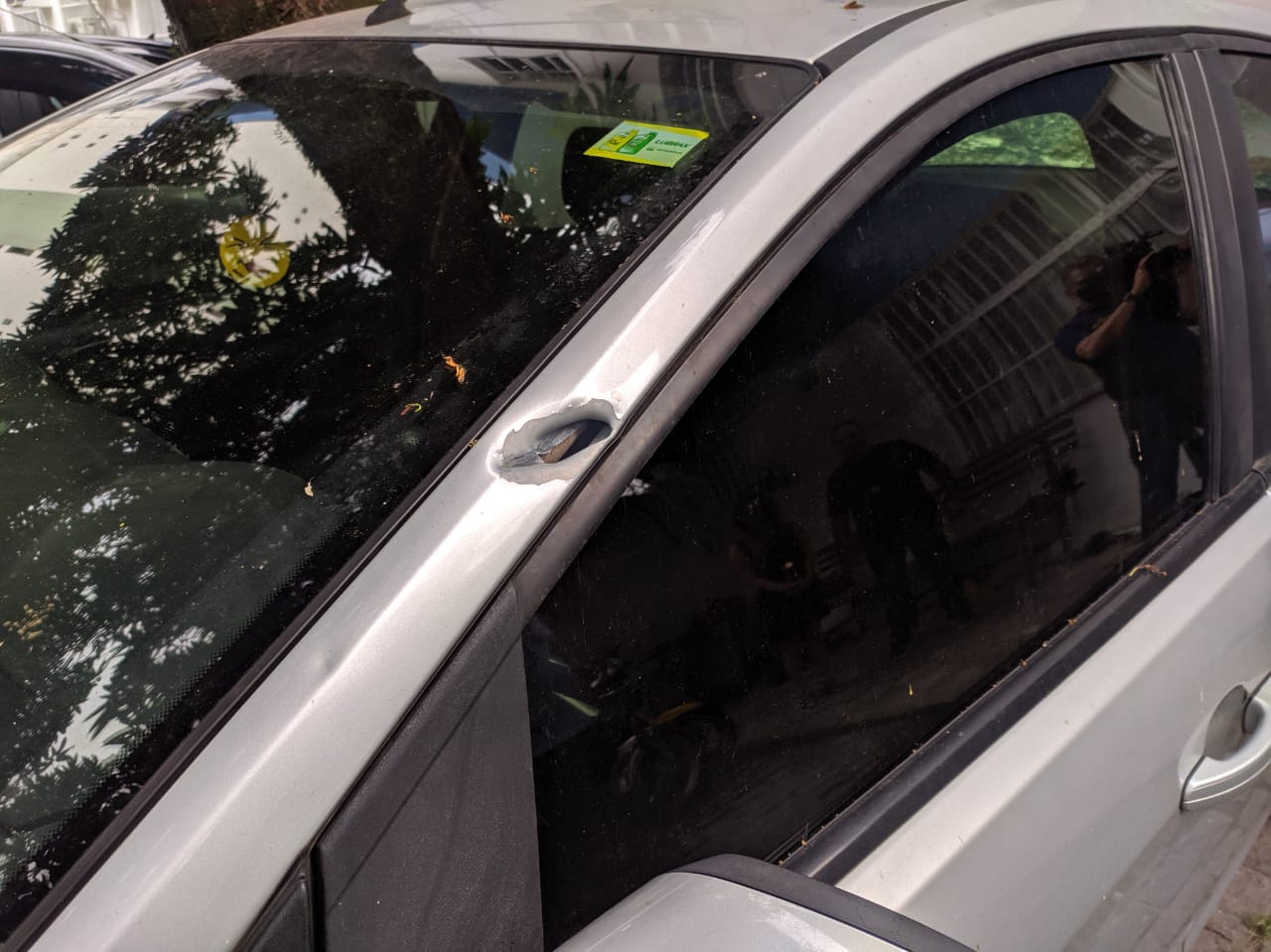 Marca de tiro em um dos carros que estava na rua (Foto: Júlia Afonso)