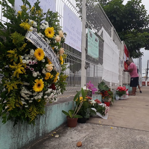 Coroa de flores foi deixada na grade da escola onde Jocival oi diretor. Cartazes também foram colados (Foto: Wilton Junior)