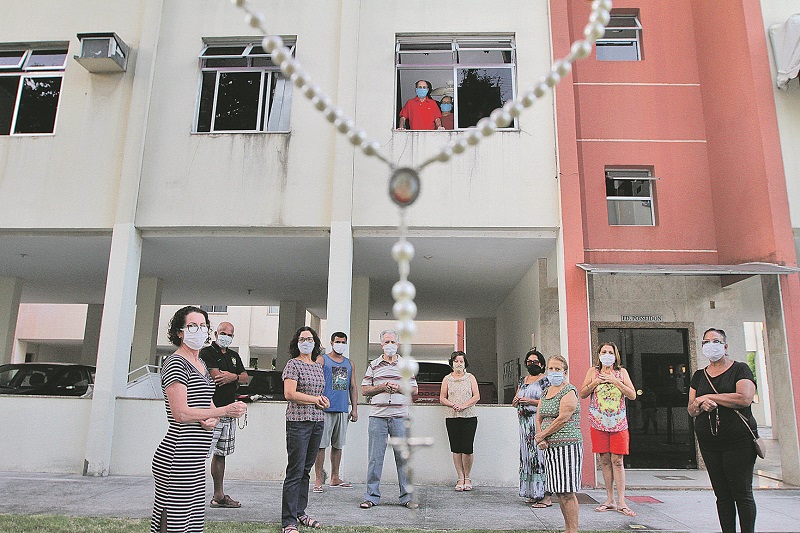 Vizinhos se reuniram em frente ao apartamento de Edson Luiz (na janela) para agradecer a Deus a cura da doença (Foto: Beto Morais/ AT)