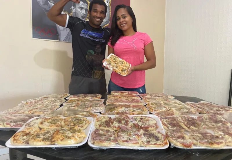 O boxeador Esquiva Falcão mostra as mini-pizzas que a esposa Suelen tem produzido em casa. 