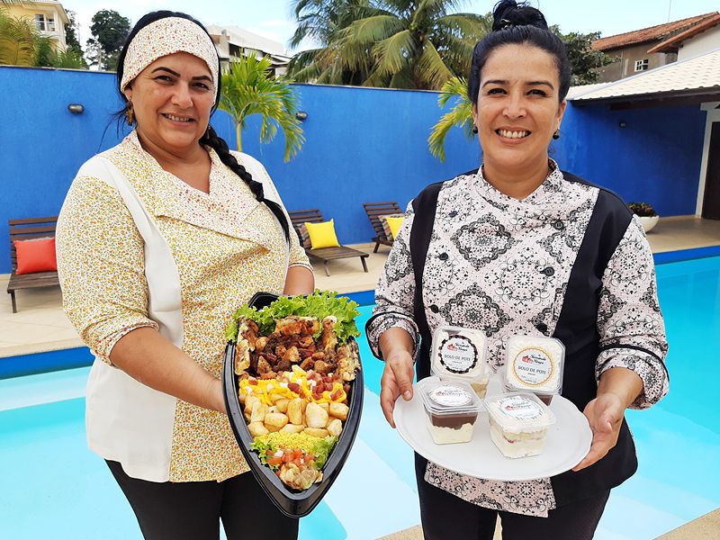 Andreia Braga e Fernanda Braga seguram, respectivamente, a barca de espetos e opções de bolo no pote (Foto: Roberta Bourguignon)