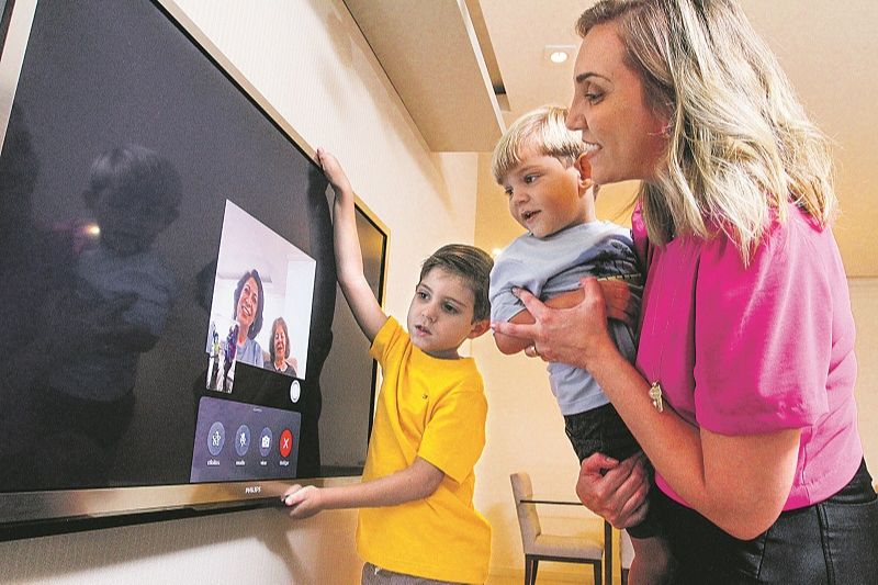Flávia Gama coloca os filhos Pedro, 5 anos, e Arthur, 2, para conversarem com a avó e a bisavó por videochamada (Foto: Beto Morais/AT)