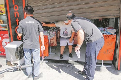 Fiscais da Prefeitura de Cariacica orientaram comerciantes a realizar atendimentos com meia porta aberta e por agendamento para evitar aglomerações (Foto: Fábio Nunes/AT)