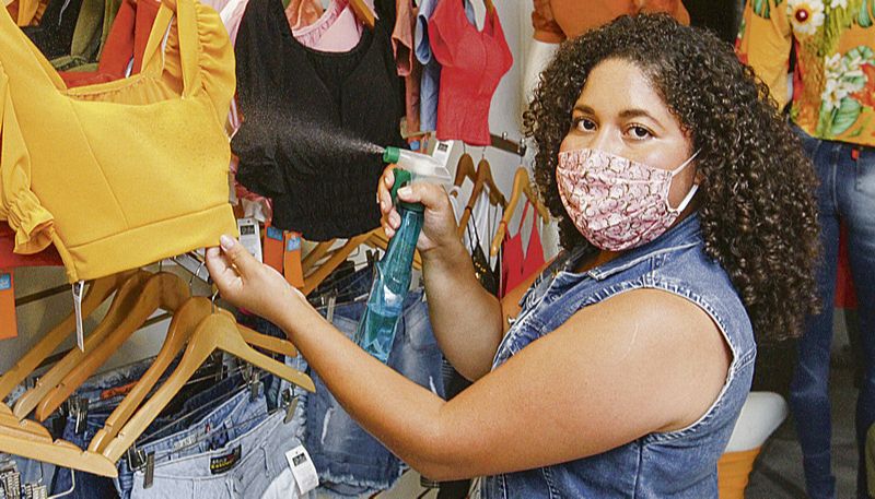 Islene disse que loja está preparada para receber clientes e que vai higienizar roupas provadas com álcool líquido (Foto: Leone Iglesias / AT)