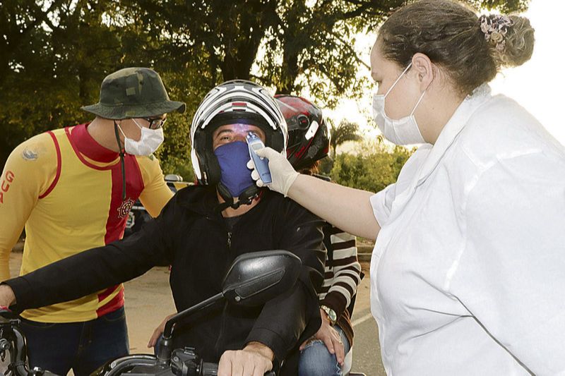 Motociclista passa por medição de temperatura em barreira sanitária na rodovia que dá acesso a Marataízes, no Sul do Estado (Foto: Alessandro de Paula / AT)