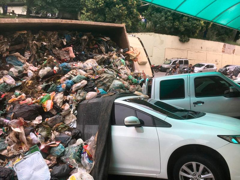 Caminhão derramou o lixo em cima de dois veículos (Foto: Alessandro de Paula)