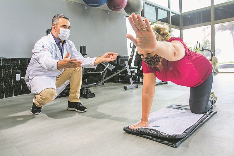 O fisioterapeuta Fabricio Alves está tratando a paciente Simone Erlacher, que está com dores na coluna. (Foto: Dayana Souza/AT)