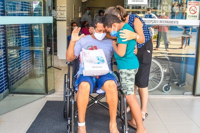 Alessandro recebe abraço da esposa e do filho ao deixar hospital onde ficou internado por 11 dias (Foto: Felipe Tozatto/Prefeitura de Linhares)