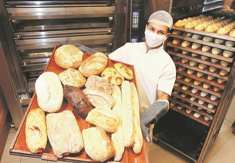 O padeiro Vinicius Dantas Januário mostra os vários tipos  de pães feitos em estabelecimento