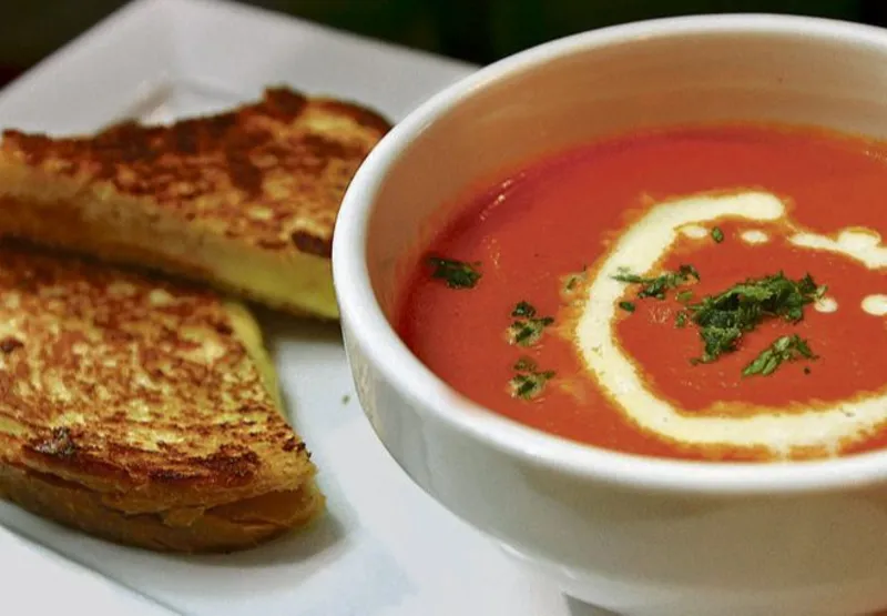 Sopa de tomate com creme de leite e queijo grelhado, acompanhado de sanduíche