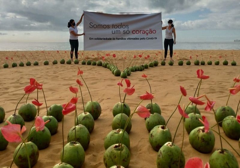 Ivana e Maria Amália seguram cartaz em homenagem às famílias que perderam entes queridos. (Foto: Divulgação)