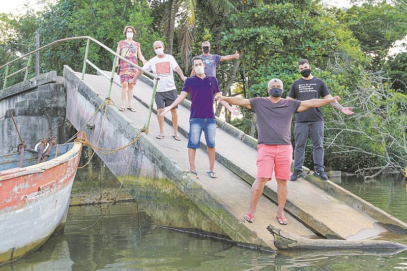Moradores sobre parte da ponte que desabou em dezembro de 2017. Reconstrução foi anunciada no dia seguinte (Foto: Leone Iglesias/AT)