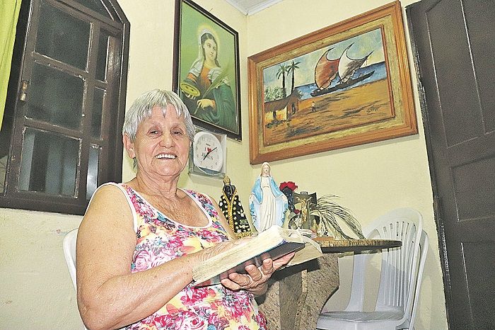 Dona Maria da Conceição, em casa, com a Bíblia. “As pessoas reclamam da vida. Eu não. Faço de bom coração” (Foto: Alessandro de Paula)