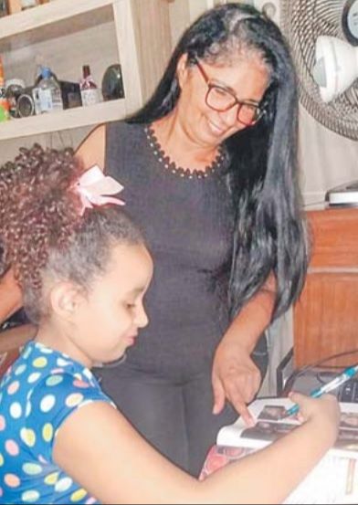 A dona de casa Roseni Dias ajuda a neta Hevellyn, de 8 anos, a estudar. (Foto: Divulgação)