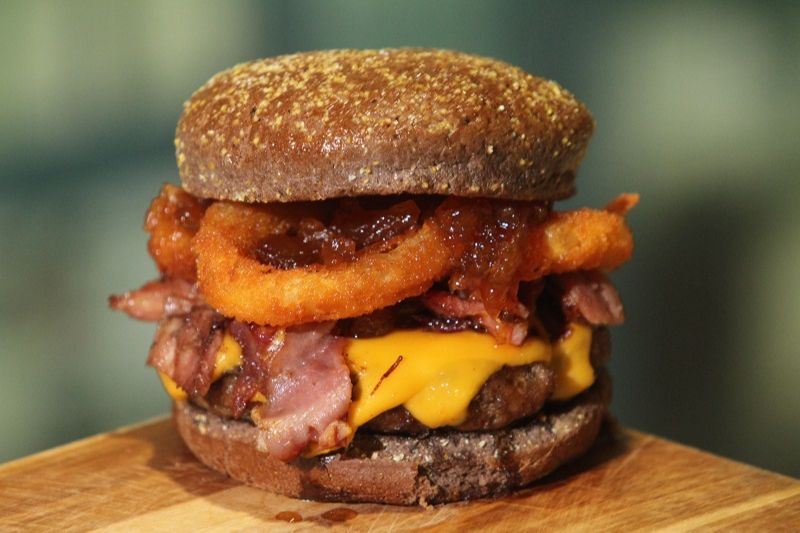 Sanduba feito no pão australiano, levemente doce, com blend de 160g de carne, duas camadas de cheddar, anéis de cebola e bacon. (Foto: Beto morais/AT)