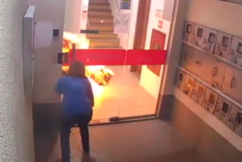 Com o corpo em chamas, a vítima tentou sair do prédio para pedir ajuda. (Foto: Reprodução/vídeo)