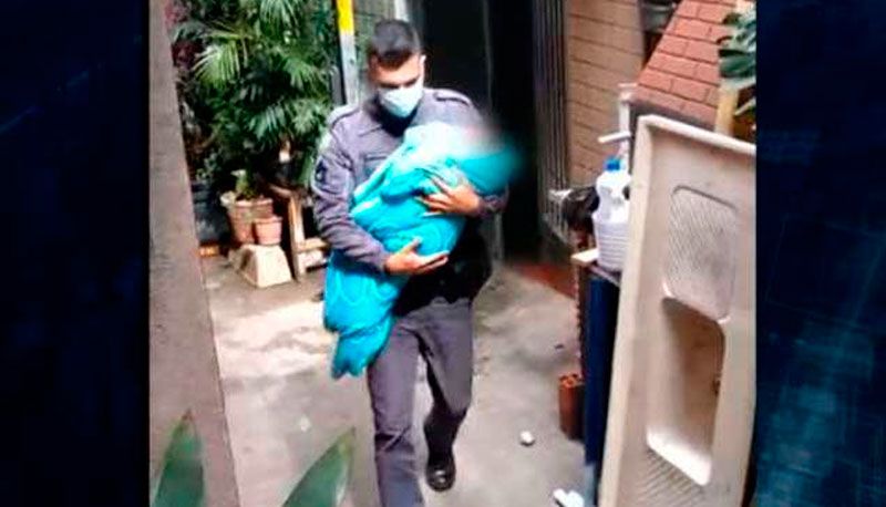 Policial carrega o bebê resgatado (Foto: Reprodução / SBT)