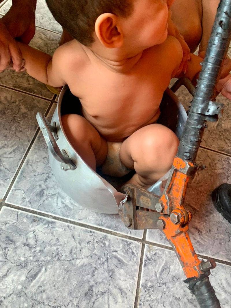 Familiares seguraram criança enquanto os Bombeiros cortavam a panela (Foto: Divulgação / Corpo de Bombeiros)