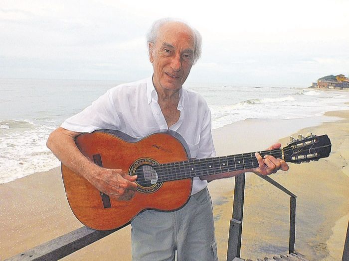 Raul Sampaio com o violão em praia de Marataízes. O cachoeirense aproveita o tempo livre para ouvir músicas e torcer pelo Fluminense (Foto: Alessandro de Paula)
