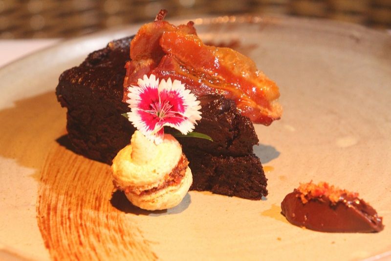Torta de chocolate cremosa e defumada, com bacon, calda de melaço e macaron com pralinê de bacon. (Foto: Beto Morais/AT)