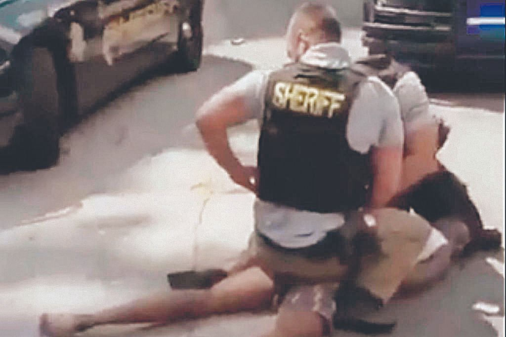 Walker no chão com dois policiais sobre ele (Foto: Reprodução de vídeo)