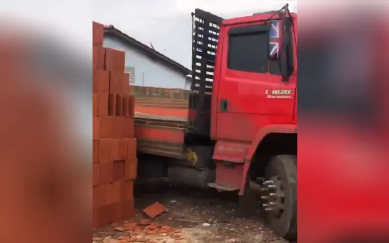Imagem ilustrativa da imagem VÍDEO | Motorista viraliza após descarregar tijolos e "prender" caminhão em lote