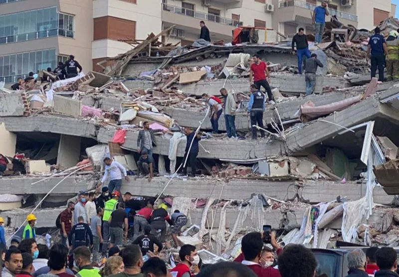 Equipes de resgate e moradores procuram por vítimas nos escombros de um prédio 