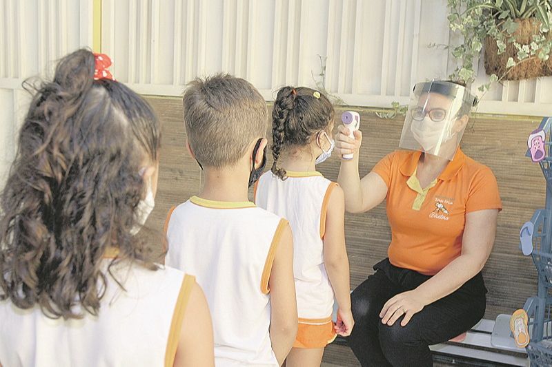 Diretora Rejane Frederich faz aferição de temperatura dos alunos na entrada da creche Idade Ativa, na Serra (Foto: Kadidja Fernandes/AT)